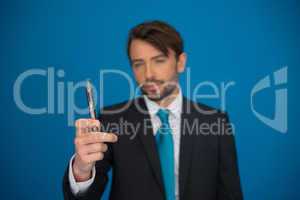 businessman with e-cigarette wearing suit and tie on blue