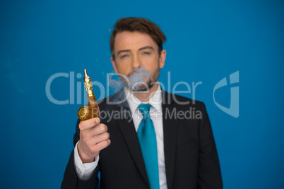 businessman with e-cigarette wearing suit and tie on blue