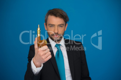 businessman with e-cigarette wearing suit and tie on blue