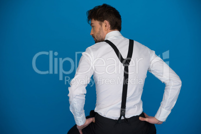 handsome man on blue wearing white shirt and braces