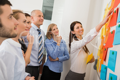 businesswoman pointing labels on whiteboard