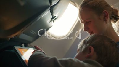 mother and son with touchpad in the plane