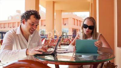 young couple with laptop and pad