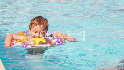 boy swimming with inflatable ring