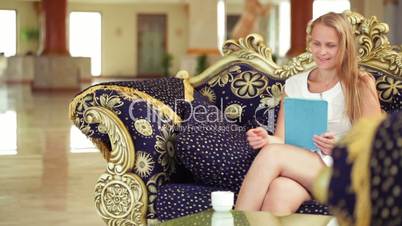 Beautiful woman using tablet in a hotel lobby