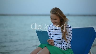 Woman with touchpad by the sea