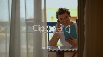 Man busy with phone talk and touchpad
