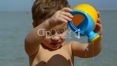 little boy having fun with toy waterpot