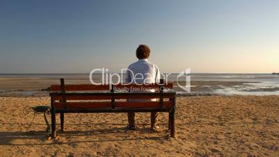 man sitting alone on the beach