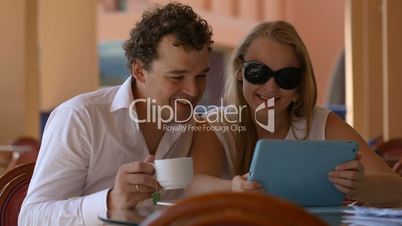 Loving couple in cafe with touchpad