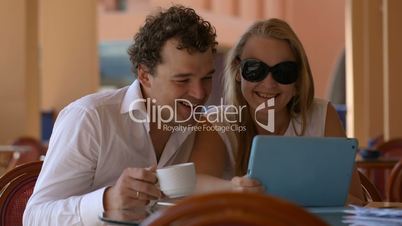 Man and woman watching photos on tablet pc