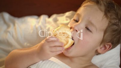 cute kid with a bun in bed