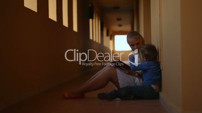 Mother and son with book in hotel hall