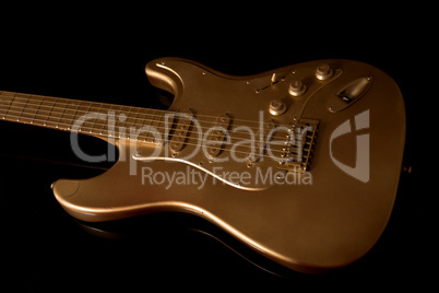 gold electric guitar on a dark background
