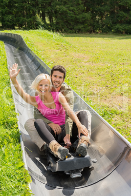 happy couple enjoying summer sledge