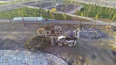 Excavator moving sand soil at construction area view from aerial camera