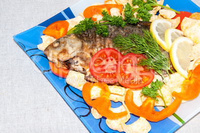 Fresh crucian river fish fried in lemon juice and fresh herbs