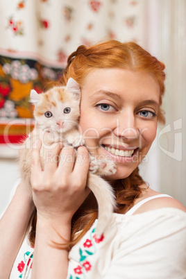 Red-haired girl with a red kitten