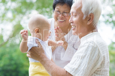 asian grandparents playing with grandson