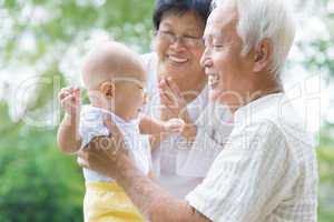 asian grandparents playing with grandson