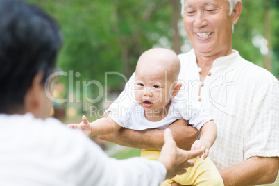 asian grandparents playing with grandchild