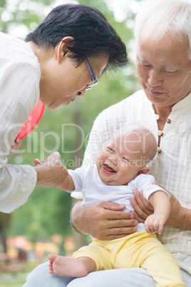 asian grandparents playing with grandchild