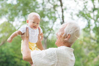 asian grandfather carrying grandson
