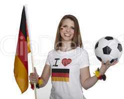 attractive woman shows german flag and football and smiles in front of white background