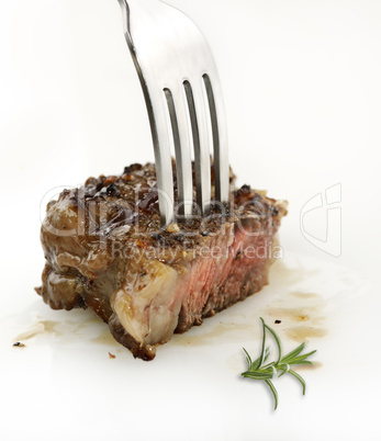 piece of red  meat steak on a fork