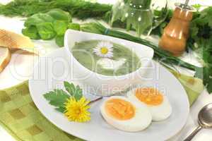 kräutersuppe mit eiern und sahneklecks