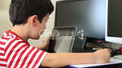 little boy doing homework with digital tablet