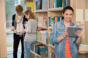 student holding tablet in library