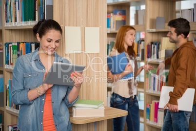university student looking at tablet in library