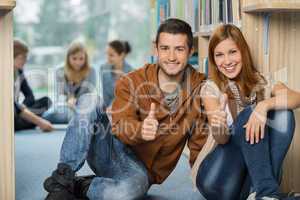 happy students showing thumb up in library