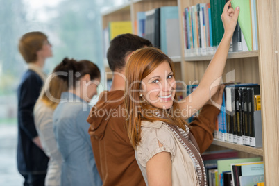 student choosing book from bookshelf in library