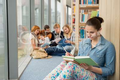 student sitting in college library with friends