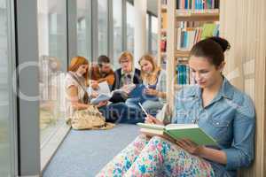 student sitting in college library with friends