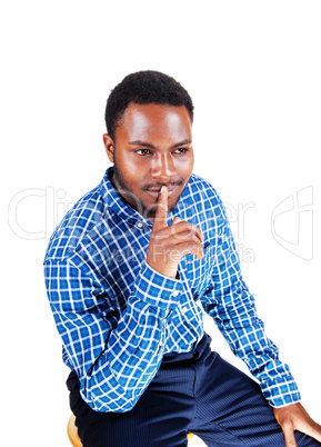black man with finger on his mouth.