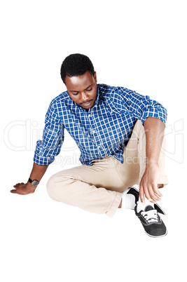 black man sitting on floor.