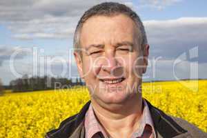 farmer stands in rape field