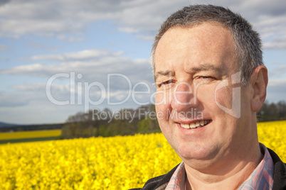 farmer stands in rape field