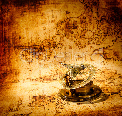 vintage compass lies on an ancient world map.