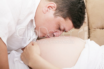 man kiss a stomach of the pregnant woman