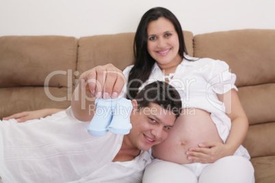happy couple expecting a baby with socks in hand.  focus in the