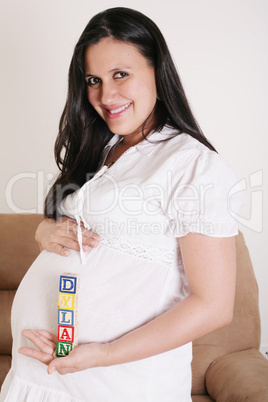 close up of a pregnant woman with baby letters on her hand