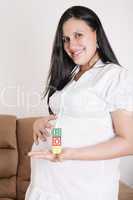 beautiful hispanic pregnant woman having the word boy with woode