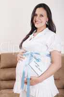 pregnant belly with a light blue ribbon and a tag saying do not