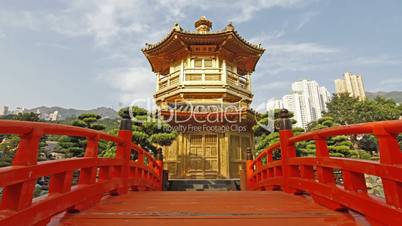 red wooden arch bridge and golden pavilion