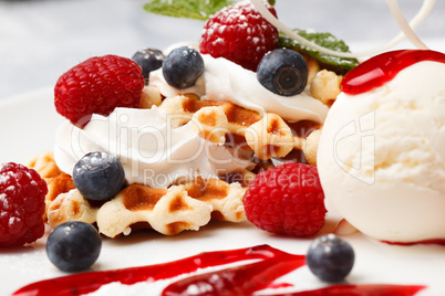waffle with cream, ice cream and fresh berries