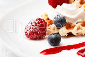 golden waffle served with cream and berries